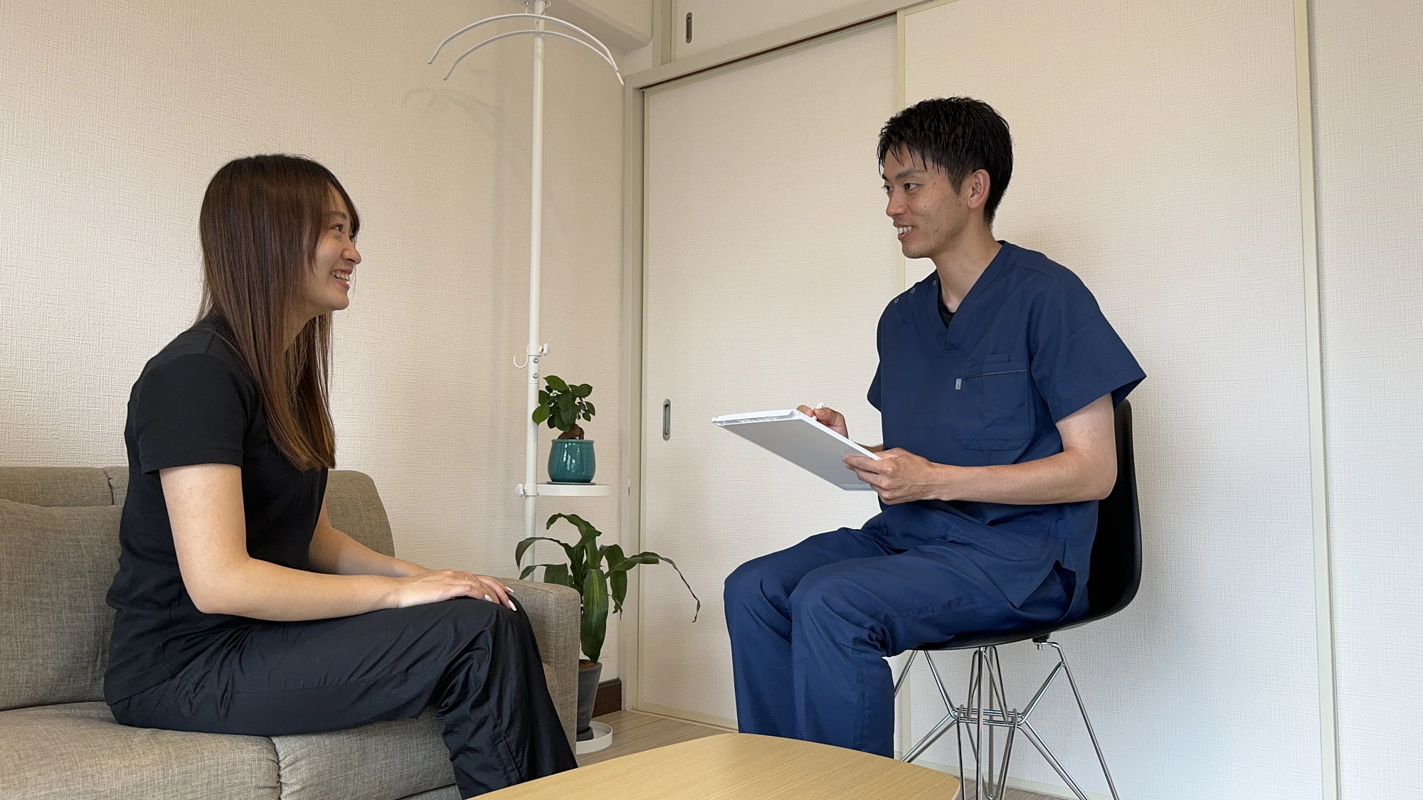 施術者が座って相手と対面で話を聞いている様子